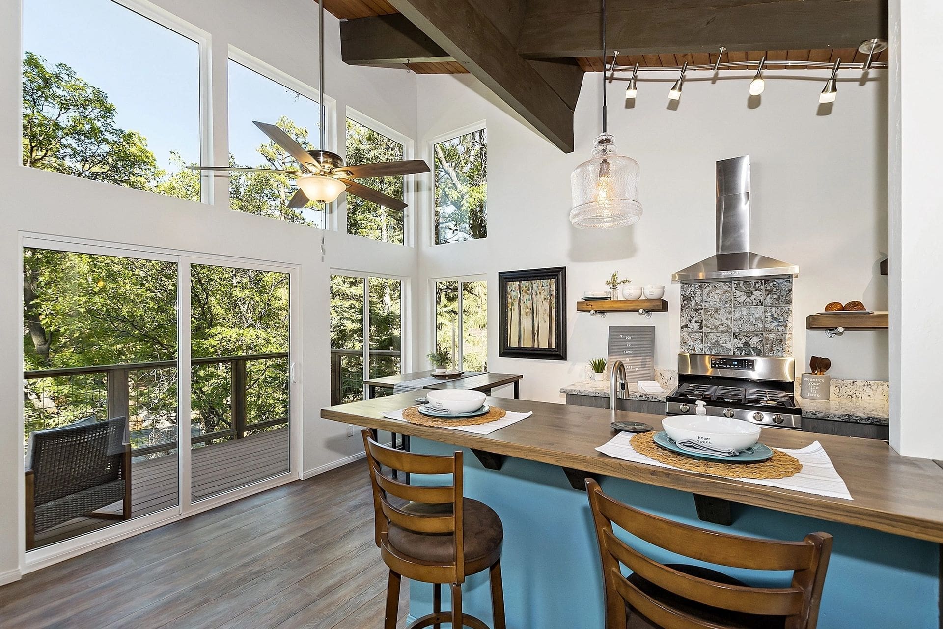 A kitchen with a large window and wooden floors