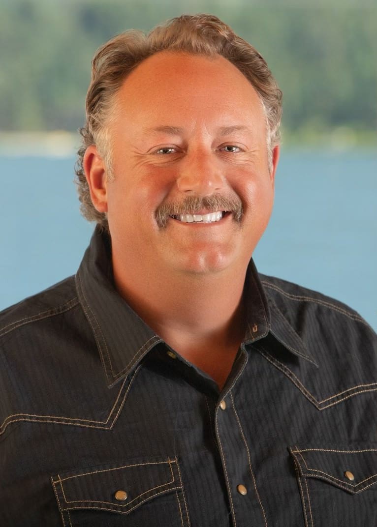 A man with a mustache and beard wearing a black shirt.