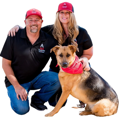 A man and woman sitting next to a dog.